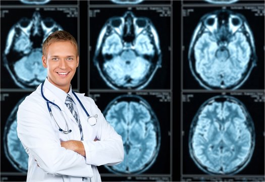 Doctor holding stethoscope standing near MRI Scanner images