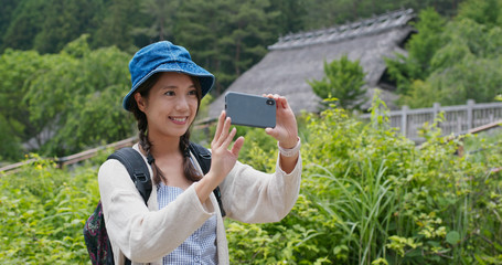 Woman travel in the countryside in Japan and use cellphone to take photo