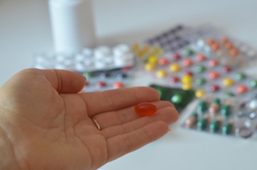 selective focus Medicine pills or capsules in hand, palm or fingers. Drug prescription for treatment medication. Woman, young female, person taking vitamin, painkiller, antibiotic