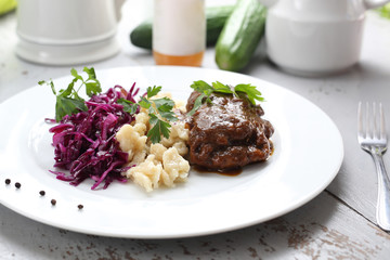 Seitan roulades with laid dumplings and red cabbage salad.