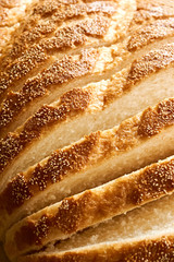 Slices of bread. Extreme closeup of freshly baked white sliced country bread with a crispy crust for use as a bakery background.. Vertical image.