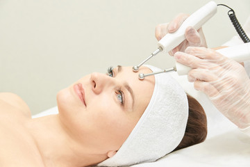 Microcurrent esthetics procedure. Beauty girl face. Cosmetology machine. Doctor hands. Two micro balls. Wrinkle reduction