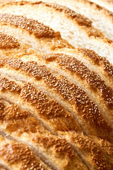 Slices of bread. Extreme closeup of freshly baked white sliced country bread with a crispy crust for use as a bakery background.. Vertical image.