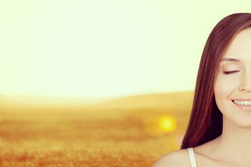 Young woman on field under sunset light