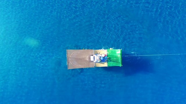 Aerial zenith view of a Shrimp boat in the Mediterranean, in front of the coast of Malaga. Picking the typical "concha fina" Malaga&rsquo;s clam (Cytherea chione). Fixed shot.
