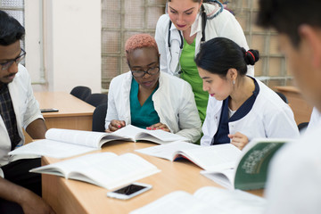 A group of mixed race doctors discussing medicine in the office at the table.