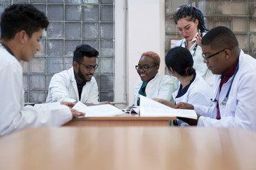 medical advice. A group of mixed-race young men, sitting at a table in a hospital office, discusses medical topics.