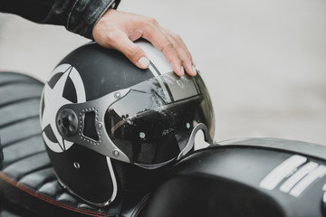 A man's hand and a helmet on a motorcycle