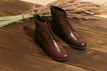 Stylish fashion shoes boots footwear concept on brown wooden background. Urban footwear advertising on wood