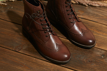 Stylish fashion shoes boots footwear concept on brown wooden background. Urban footwear advertising on wood