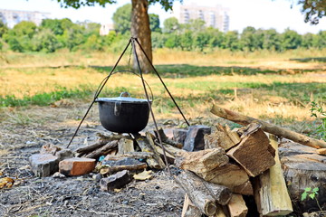 Cooking barbecue and fish soup on a bonfire on a picnic outside the city. Summer, 2019.