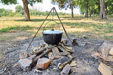 Cooking barbecue and fish soup on a bonfire on a picnic outside the city. Summer, 2019.