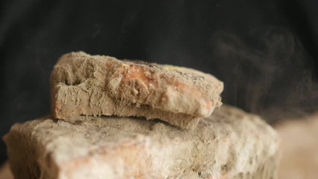 slice of bread falling on moldy bread, particles of mold slow motion, swirl, floating