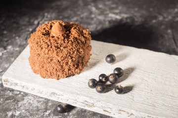 chocolate cake, on a wooden board, in a rustic style. Pastry decorated with black berry