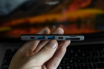 Man's hand holding The USB adapter under the Type-C connector for laptop. Multiport station for...