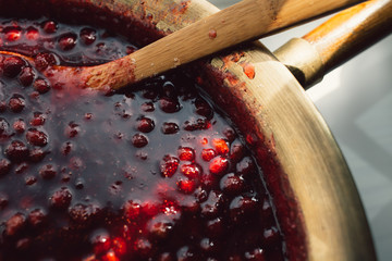 spoon immersed in a bowl with strawberry jam, food background