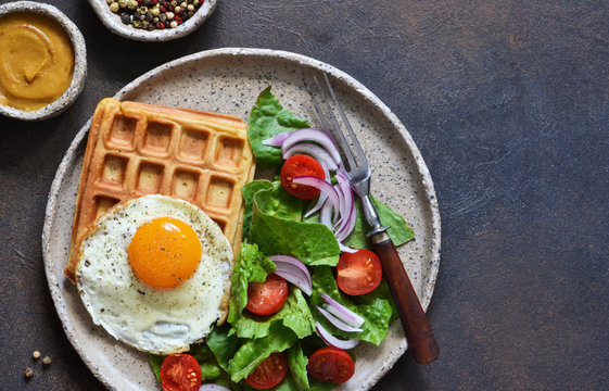 Belgian Waffles With Egg And Salad For Breakfast In A Plate On The Kitchen Table. View From Above.