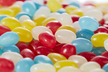 Colored caramels of different colors in the shape of beans closeup. Candy and sweets.