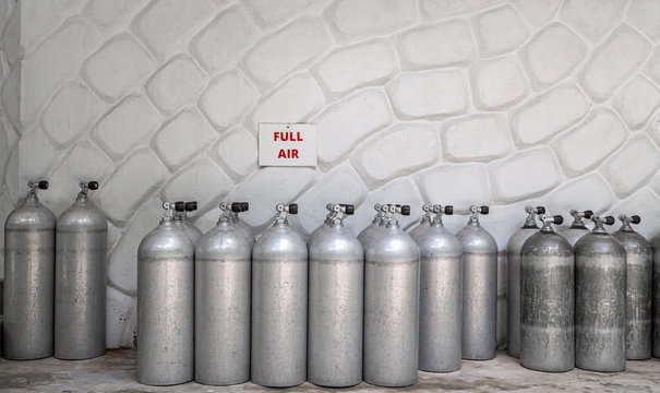 viele Tauchflaschen stehen vor einer wei&szlig;en Wand