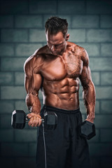 Fototapeta na wymiar Bodybuilder Execising With Weights. Studio Shot of Muscular Men Lifting Weights