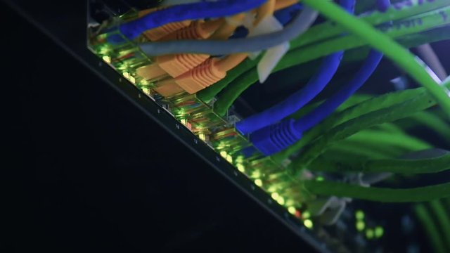 Closeup of a router with lan cables plugged and led lights blinking.