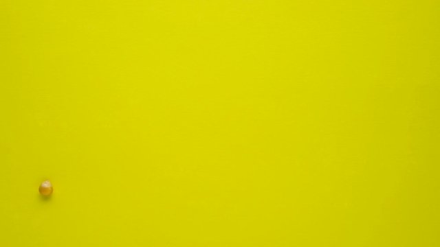 Stop motion creative concept video footage food popcorn seeds on yellow background.