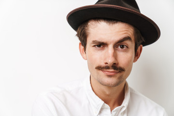 Portrait closeup of attractive mustached man wearing hat and shirt looking at camera