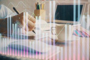 Financial chart drawn over hands taking notes background. Concept of research. Double exposure