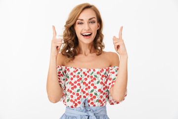 Portrait of seductive happy woman wearing summer clothes pointing fingers upward at copyspace and smiling