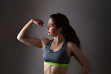 Fototapeta na wymiar Sport and health. Portrait of a beautiful athletic young woman in sportswear that shows off the bicep