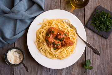 Delicious spaghetti with meatballs in tomato sauce on dark background, italian cuisine