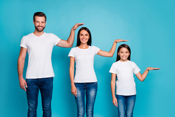 Portrait of charming family holding palm wearing white t-shirt denim jeans isolated over blue background