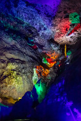 Beautiful illuminated multicolored stalactites in Danzhou Stone Flower Caves, Geopark next to Haikou, Hainan, China
