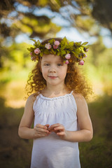 Red hair girl walking into woods with flowers.