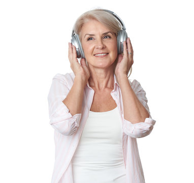 Beautiful 50 Years Old Woman Is Listening To Music In Headphones