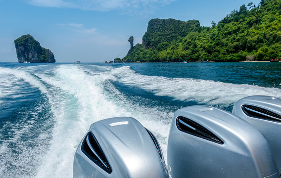 Splash wave water from Speed Boat's Engines with Full Speed Drive on blue sea with beautiful sky and Chicken island in Krabi, Thailand.