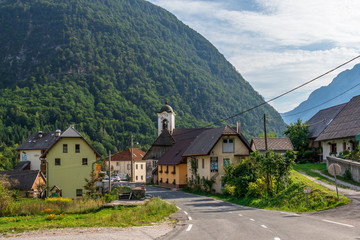 Street Scenario of Village Log pod Mangartom from north direction of predil pass with Julian Alps. Bovec, Slovenia, Europe.
