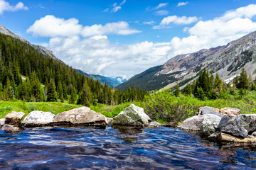 Hot springs blue pool on Conundrum Creek Trail in Aspen, Colorado in 2019 summer with rocks stones...