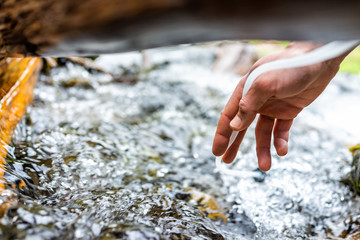 Man hand using water filter on hiking trail river in Colorado to purify drinking water using silicone tube