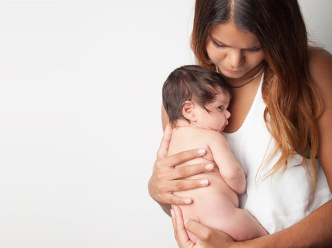 Australian mother holding newborn baby girl on white background
