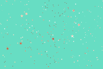 Green mint background with rose gold glitter and metallic stars. Flat lay style