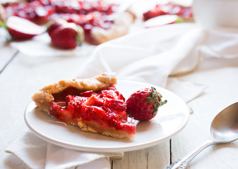 Homemade sweet strawberry cake with fresh strawberries on white wooden table