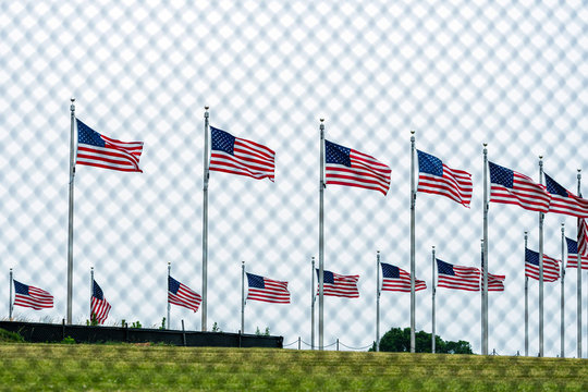 American flags at the Washington Memorial behind the wire fence. Focus on flags - image