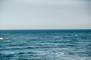 Blue sea with waves and cloudy sky background. Atlantic ocean.  