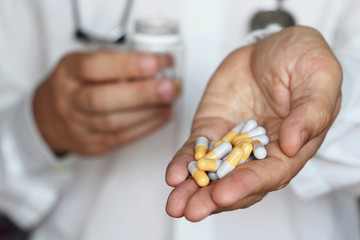 Doctor giving pills, physician holding in palm of hand medication in capsules. Concept of dose of drugs during cold season, vitamins, medical exam, pharmacy, anti-inflammatory
