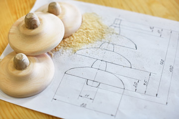 Wooden blanks are on paper with a drawing. Production of products in the carpentry workshop.