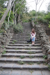 Fototapeta na wymiar beautiful girl sits on the old steps