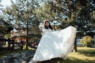 Beautiful bride with wedding bouquet of roses, attractive woman in wedding dress. Happy newlywed woman. Smiling bride. Wedding day. Gorgeous bride. Marriage. Bride with wedding makeup and hairstyle. 