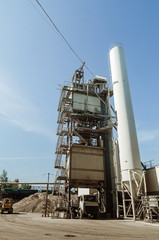 Equipment for production of asphalt, cement and concrete. Concrete plant. High tower of an asphalt plant. Harmful production. A mixture of bitumen and gravel, a mix machine.
