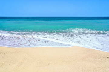 Fototapeta na wymiar At a lonely sandy beach and turquoise sea